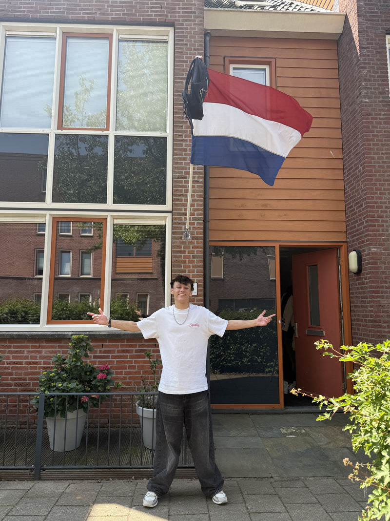 Geslaagde leerling van MyTutor uit de Class of 2025 met vlag en schooltas